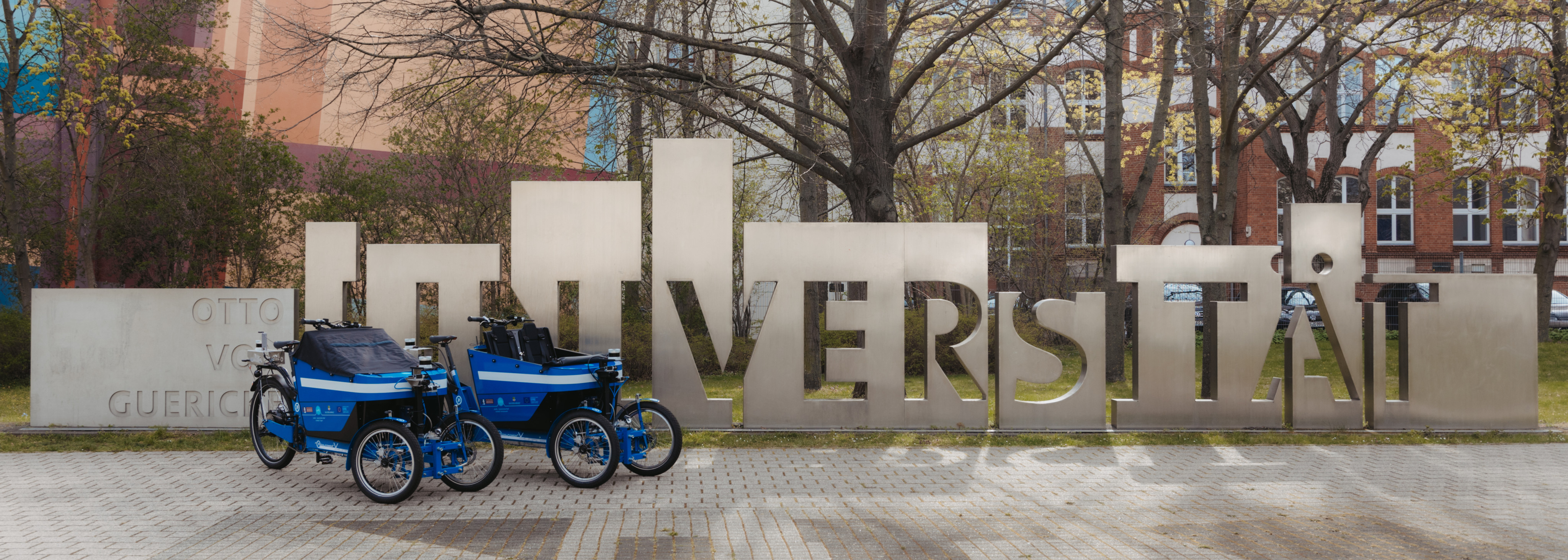 Zwei blaue Lastenräder vor der Uni-Porta der OVGU